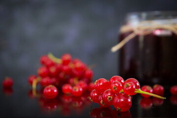 Jar with jam of red currant on dark background