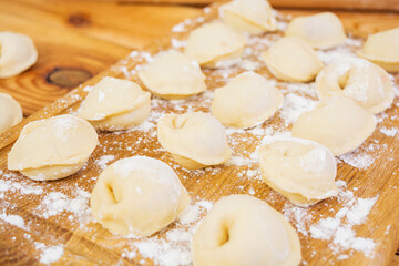 Meat dumplings, ravioli, on wooden background