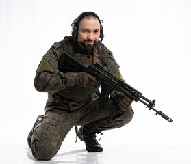 soldier in the studio on a white background. a man in military uniform with a rifle or machine gun. military or airball player