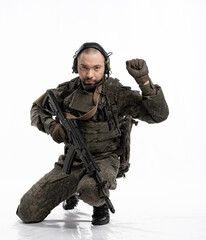 soldier in the studio on a white background. a man in military uniform with a rifle or machine gun....