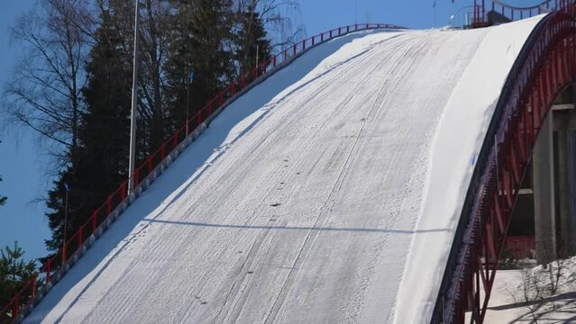 Close up shot of ski jumper jumping on the snowy track