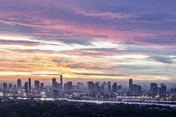 Fototapeta premium Bangkok,Thailnad - Jul 23, 2022 : Gorgeous scenic of the sunrise or sunset with beautiful cloud and sky over large metropolitan city in Bangkok. Copy space, Selective focus.