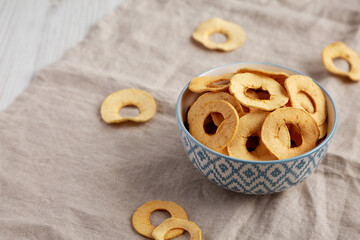 Homemade apple chips in a bowl, side view. Copy space.