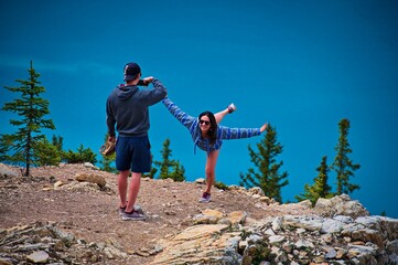 Mature couple having fun at the edge of the rock above the Peyto lake in Canada