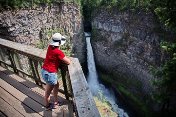 Mature woman railing above the scenic waterfall