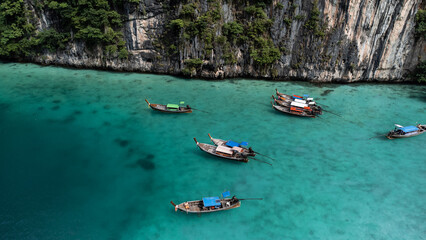 Fototapeta na wymiar Long boats in paradise. Crystal clear waters of the Phi Phi islands. Travel to Thailand