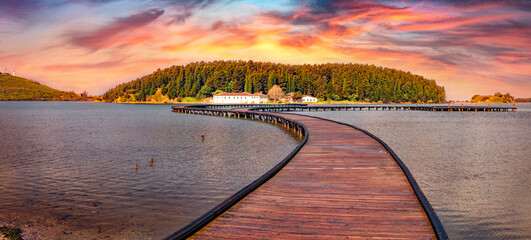 Old wooden pathbridge to St Mary's Monastery. Wobderful sunrise on Narta Lagoon. Astonishing outdoor scene of Albania, Europe. Traveling concept background.
