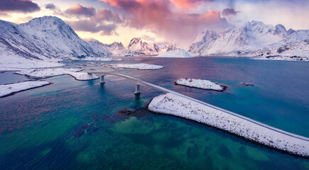 Spectacular morning scene of Fredvang bridge with Volandstind peak on background. Fantastic view from flying drone of Lofoten Islands. Majestic winter sunrise on Norway. Life over polar circle. © Andrew Mayovskyy