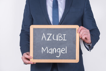 Geschäftsmann mit einer Tafel auf der AZUBI Mangel steht