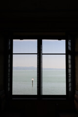 a vertical shot of Lake constance through a window, silhouette
