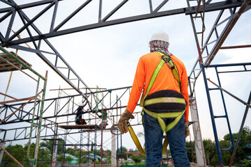 Naklejka na ściany i meble Workers prepare to go up with Fall arrestor device for worker with hooks for safety body harness on onstruction site.