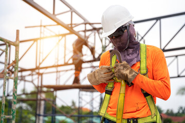 A Construction workers are installing safety equipment to prevent falls from heights or Fall...