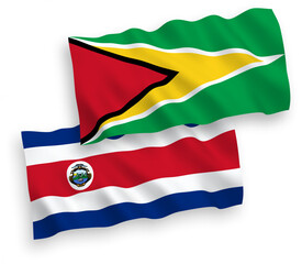 National vector fabric wave flags of Republic of Costa Rica and Co-operative Republic of Guyana isolated on white background. 1 to 2 proportion.