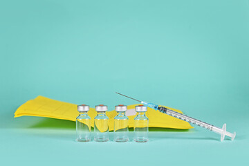 Corona booster vaccine concept with 4 vials with syringes and certificate of vaccination in background with copy space - obrazy, fototapety, plakaty