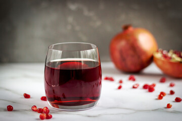 Pomegranate juice with seed on stone table background