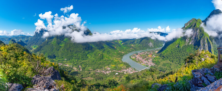 View from the top Viewpoint of Nong Khiaw - a secret village in Laos. Stunning scenery of limestone cliff valley covered with green rainforest jungle mysterious clouds.