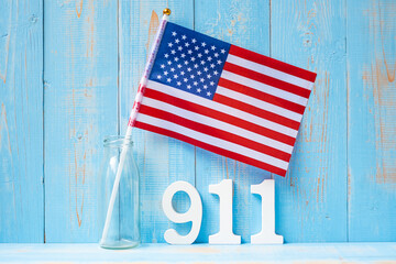 911 text and United States of America flag on wooden table background. Patriot Day, September,...
