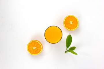 Two pieces of juicy oranges with glass of orange and green leaf isolated on white background, placed in the center of Top view concepts Background