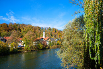 Fototapeta na wymiar pictorial autumn landscape Wolfratshausen, Loisach river and St. Andreas church. upper bavarian