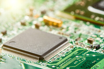 Close-up of computer chip on a part of electronic printed circuit board with sunlight