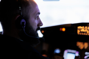 Plane captain looking through windscreen to fly aircraft, starting power engine and pushing dashboiard command buttons to takeoff. Airliner flying airplane with radar compass navigation. Close up.