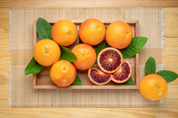 Blood oranges, or Red oranges with leaf on wooden table. 