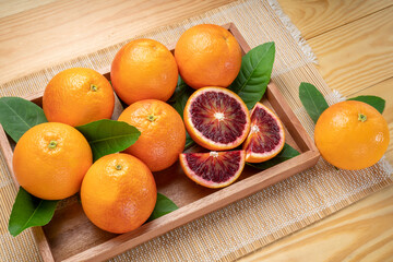 Blood oranges, or Red oranges with leaf on wooden table. 