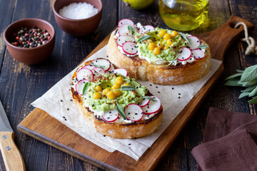 Bruschetta with guacamole, radish, white cheese, chickpeas and sage. Vegetarian food. Sandwich. Italian food.