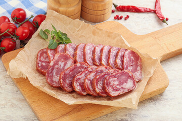 Sliced salami sausages over board