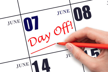 7th day of June. Hand writing text DAY OFF and drawing a line on calendar date 7 June. Vacation...