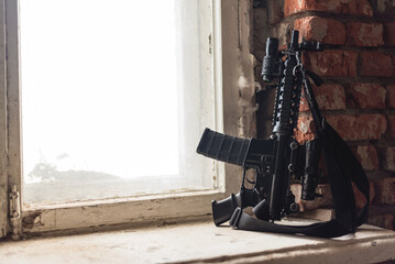 Airsoft rifle on the windowsill close up background.