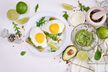 healthy breakfast or snack - sliced avocado and fried egg on toasted bread 