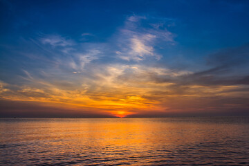 Naklejka na ściany i meble sunset sky with dramatic sunset clouds over the sea. Beautiful sunrise over Ocean