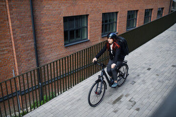 Businesswoman commuter on the way to work on bike, sustainable lifestyle concept. High angle view.