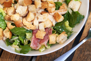 Caesar salad with croutons, lettuce, bacon and chicken