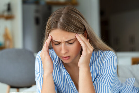 Sinus ache causing very paintful headache. Unhealthy woman in pain. Sharp strong sore. Sinus pain, sinus pressure, sinusitis. Sad woman holding her head because sinus pain
