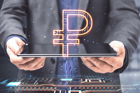 Businessman hands holding tablet with creative glowing Russian ruble hologram on blurry office interior background. Digital money and online banking concept. Double exposure.