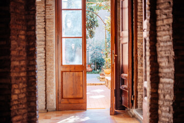 Door opening to little cosy inner courtyard garden in Italy