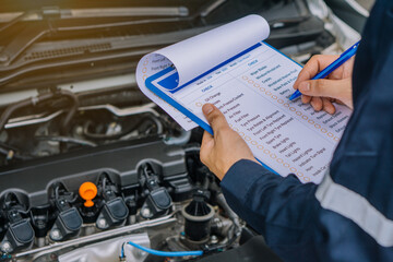 machinic man writing to the clipboard the checklist for repair machine, car service and maintenance.Services car engine machine concept.