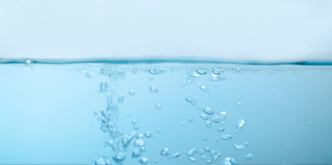 de-focused. Closeup of light blue transparent clear calm water surface texture with splashes and bubbles. Trendy abstract summer nature background. for a product, advertising,text space.