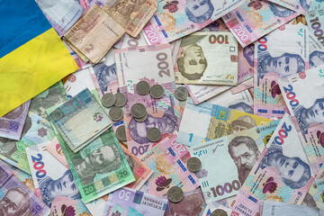 Ukrainian money paper bills wit hcoin  on national flag, top view