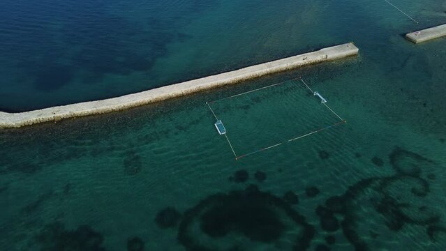 water polo field by the sea, next to a stone jetty, on the island of Rab, Croatia, without people, summer, late morning