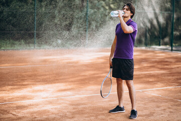 Young man tennis player at the court