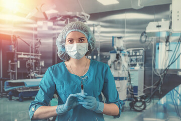 Fototapeta na wymiar Attractive female doctor holding syringe in operating room for patient.