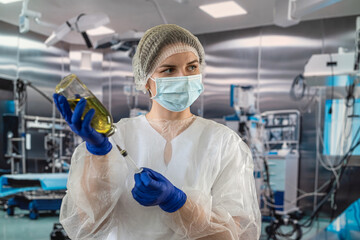 Fototapeta na wymiar female doctor in uniform face mask in gloves prepares syringe with antibiotic in operating
