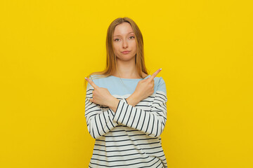 Choice, decision. Upset gloomy girl with fair-haired, sulking and frowning, pointing sideways, showing left and right, two ways, deciding, picking from variants, yellow background