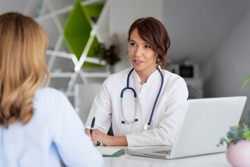 Female doctor consulting with her patient while sitting at the doctor's office