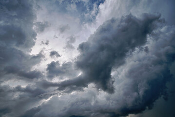 Obraz premium Stormy sky background with gray clouds before rain. Storm clouds in the sky. Weather forecast concept. Dark thunderstorm clouds and shining clouds, cloudscape. Stormcloud in the sky..