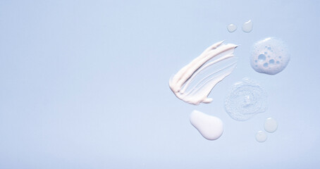 Serum and moisturizing smears cosmetic cream with on colored background. Top view. Banner format
