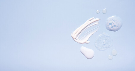 Serum and moisturizing smears cosmetic cream with on colored background. Top view. Banner format